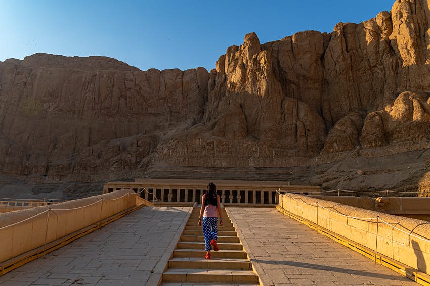 Una niña camina hacia el templo de Hatshepsut, Egipto